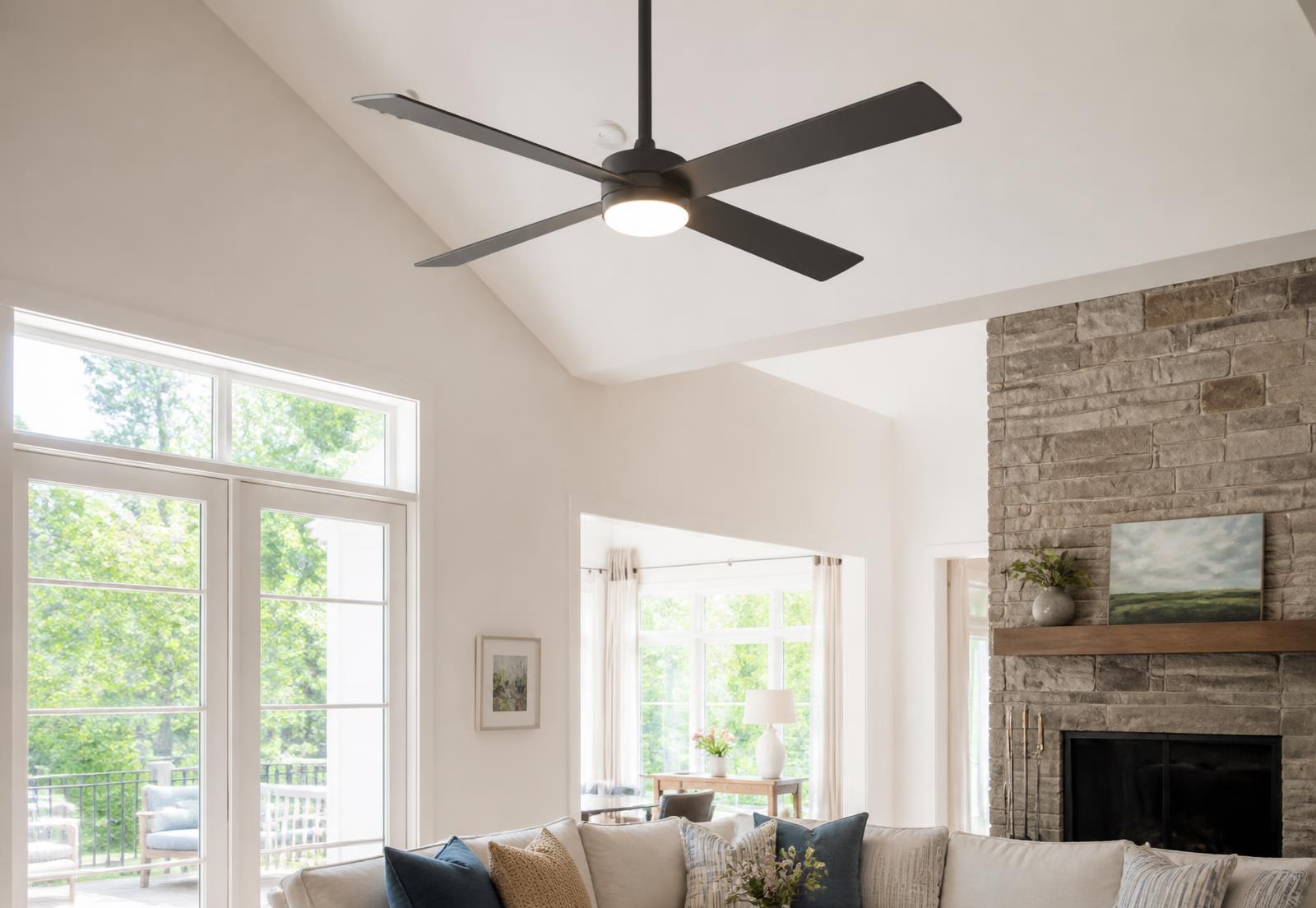 Modern dark ceiling fan with integrated light mounted on a vaulted white living room ceiling